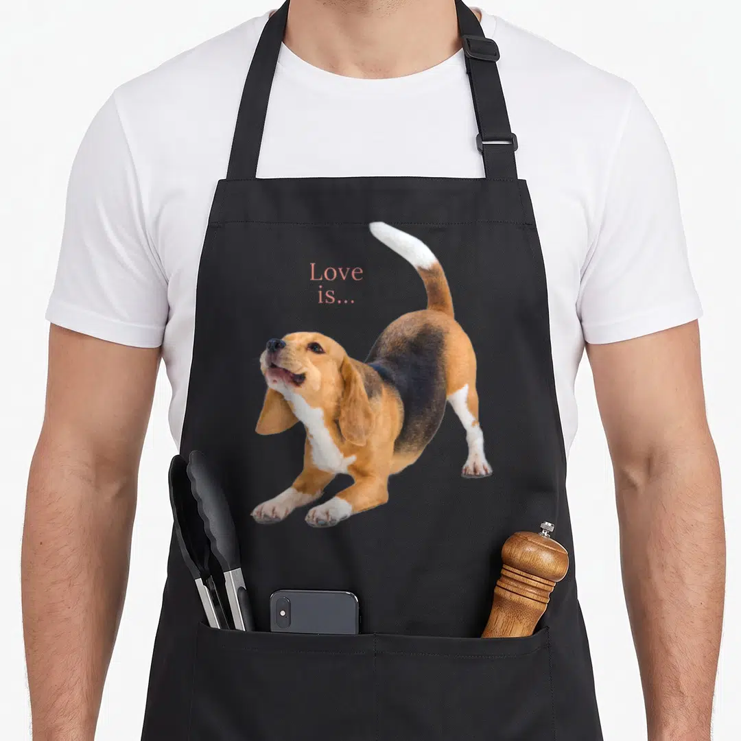 Beagle puppy dog apron - Photo of stretching beagle with pink Love is text above back — shown on a black cotton canvas apron against a white background