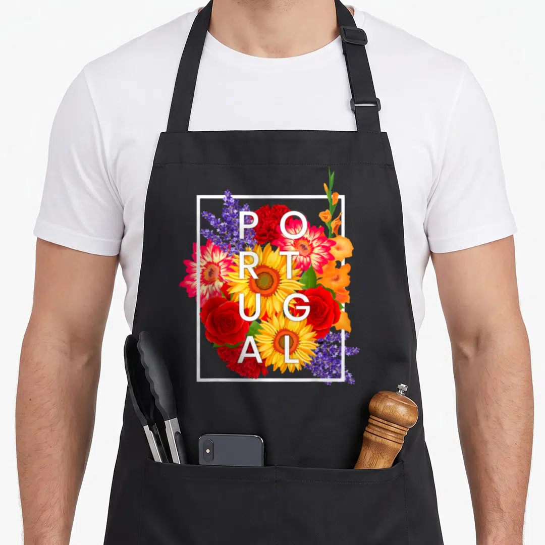 Flower portuguese apron - Vertical PORTUGAL text over red yellow purple orange and white flowers in white square frame — shown on a black cotton canvas apron against a white background
