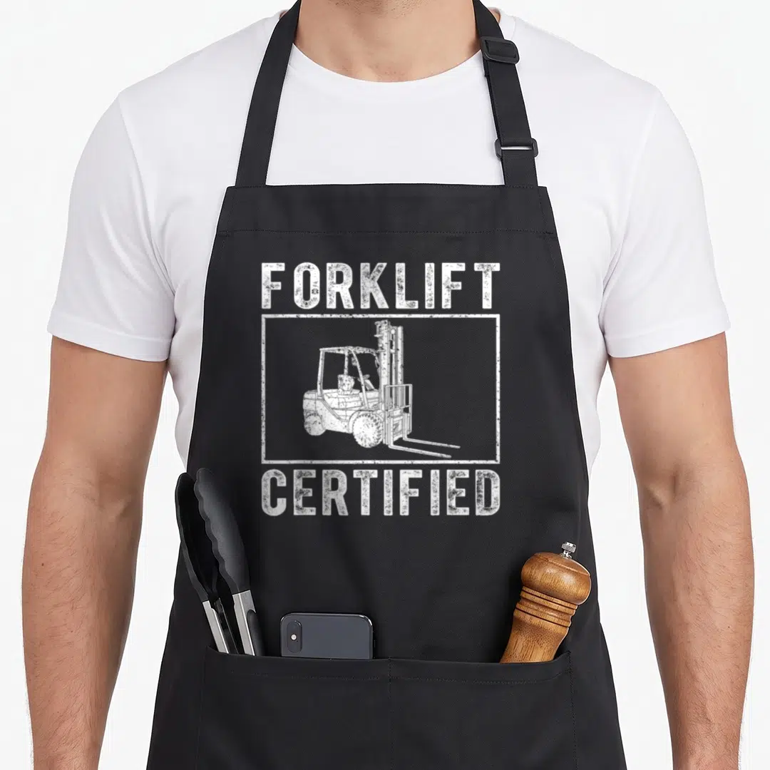 Certified forklift humor apron - White distressed text Forklift Certified with forklift illustration in rectangular — shown on a black cotton canvas apron against a white background
