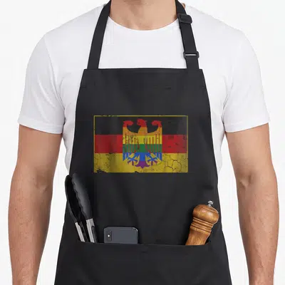 German lgbt gay pride apron - Distressed German flag with rainbow eagle emblem in black red yellow blue green purple — shown on a black cotton canvas apron against a white background