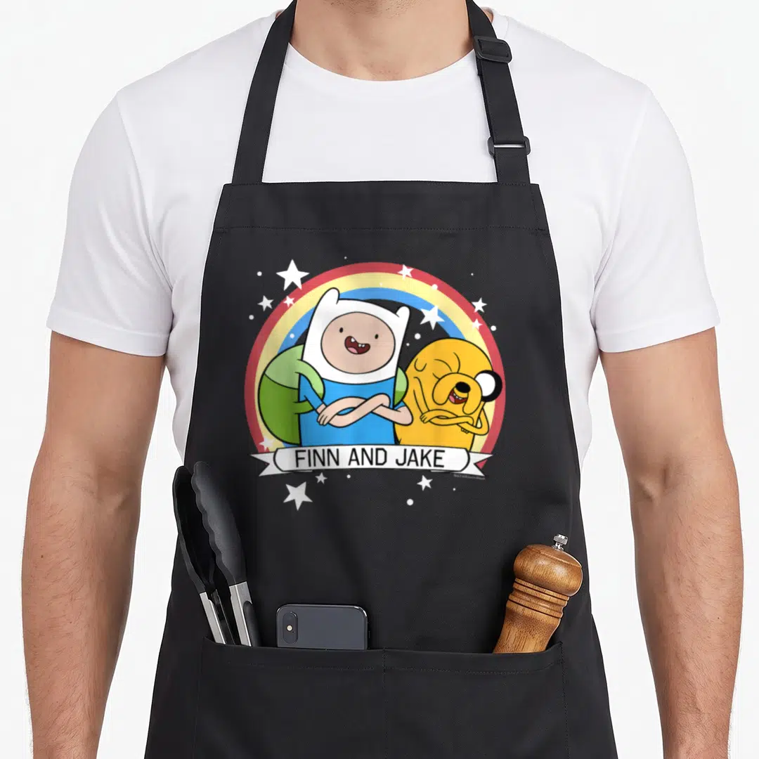 Adventure rainbow apron - Finn and Jake cartoon characters under a rainbow arc with white stars and a name banner — shown on a black cotton canvas apron against a white background