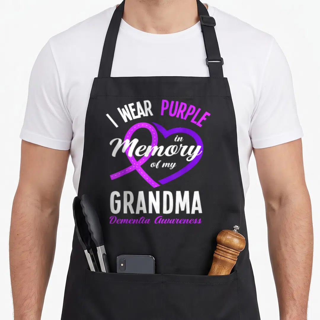 Memory grandma apron - Purple ribbon overlapping a heart with I Wear Purple in Memory of my Grandma text — shown on a black cotton canvas apron against a white background