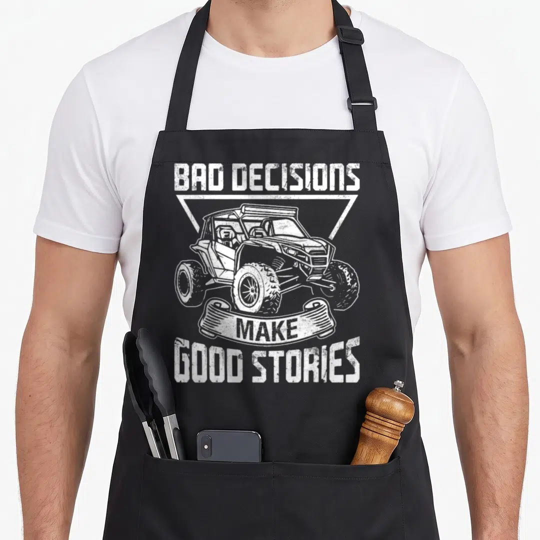 Sxs vehicle apron - Distressed white BAD DECISIONS MAKE GOOD STORIES text with UTV in triangle frame on black apron — shown on a black cotton canvas apron against a white background