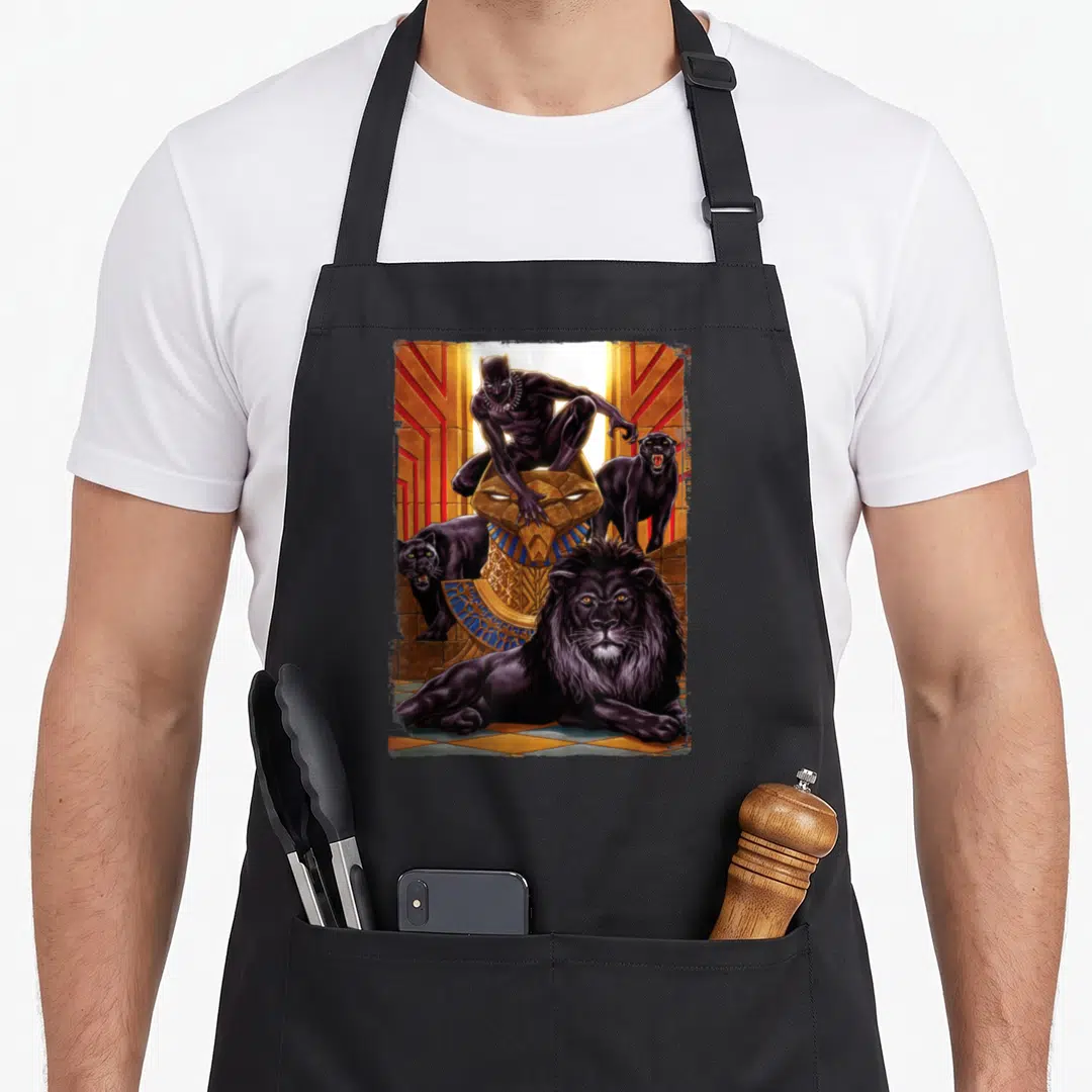 King lion apron - Black Panther perched on gold statue with black lion and two panthers in temple — shown on a black cotton canvas apron against a white background