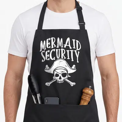 Pirate family aprons - White distressed skull with pirate hat and MERMAID SECURITY text — shown on a black cotton canvas apron against a white background
