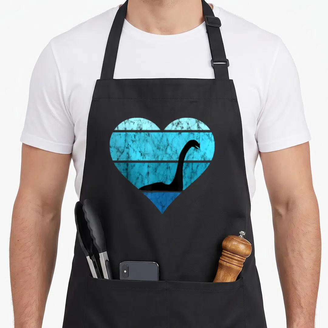 Ocean loch ness monster apron - Black dinosaur silhouette inside a heart with four distressed blue horizontal bands — shown on a black cotton canvas apron against a white background
