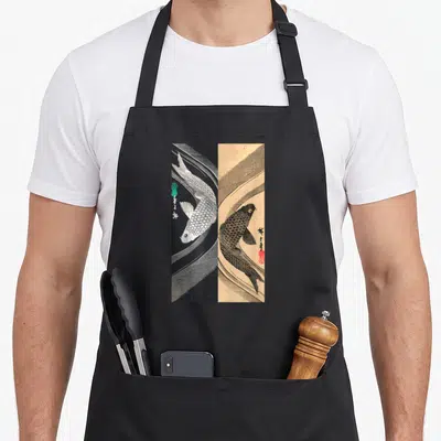 Funny japanese fish apron - Split panel koi fish print white on black and black on tan with red seal — shown on a black cotton canvas apron against a white background