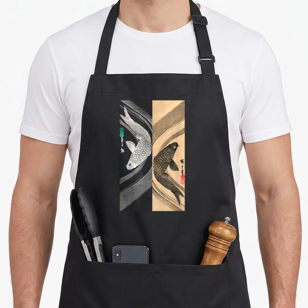Funny japanese fish apron - Split panel koi fish print white on black and black on tan with red seal — shown on a black cotton canvas apron against a white background
