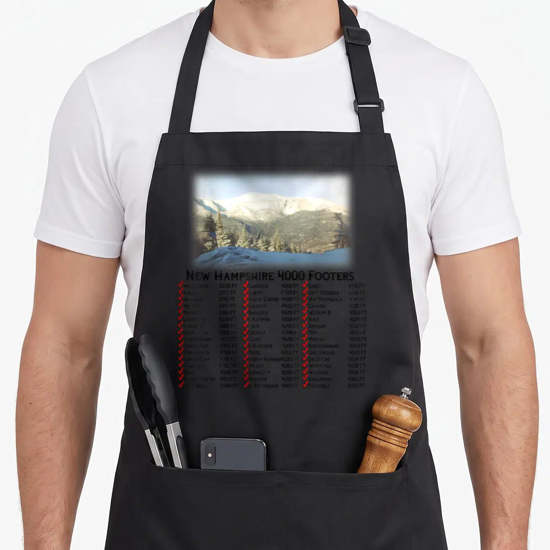 Footer hampshire apron - Snowy mountain photo above a three-column list of peak names and altitudes with red checkboxes — shown on a black cotton canvas apron against a white background
