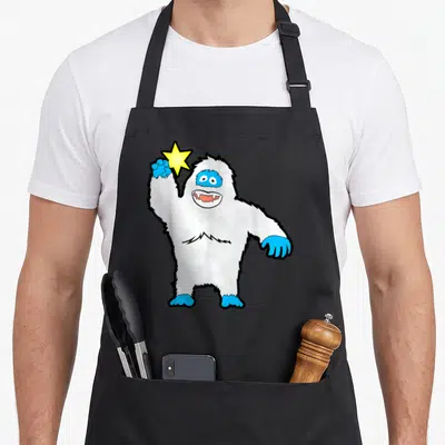Bigfoot snowman apron - White cartoon yeti holding yellow star with blue hands and feet — shown on a black cotton canvas apron against a white background