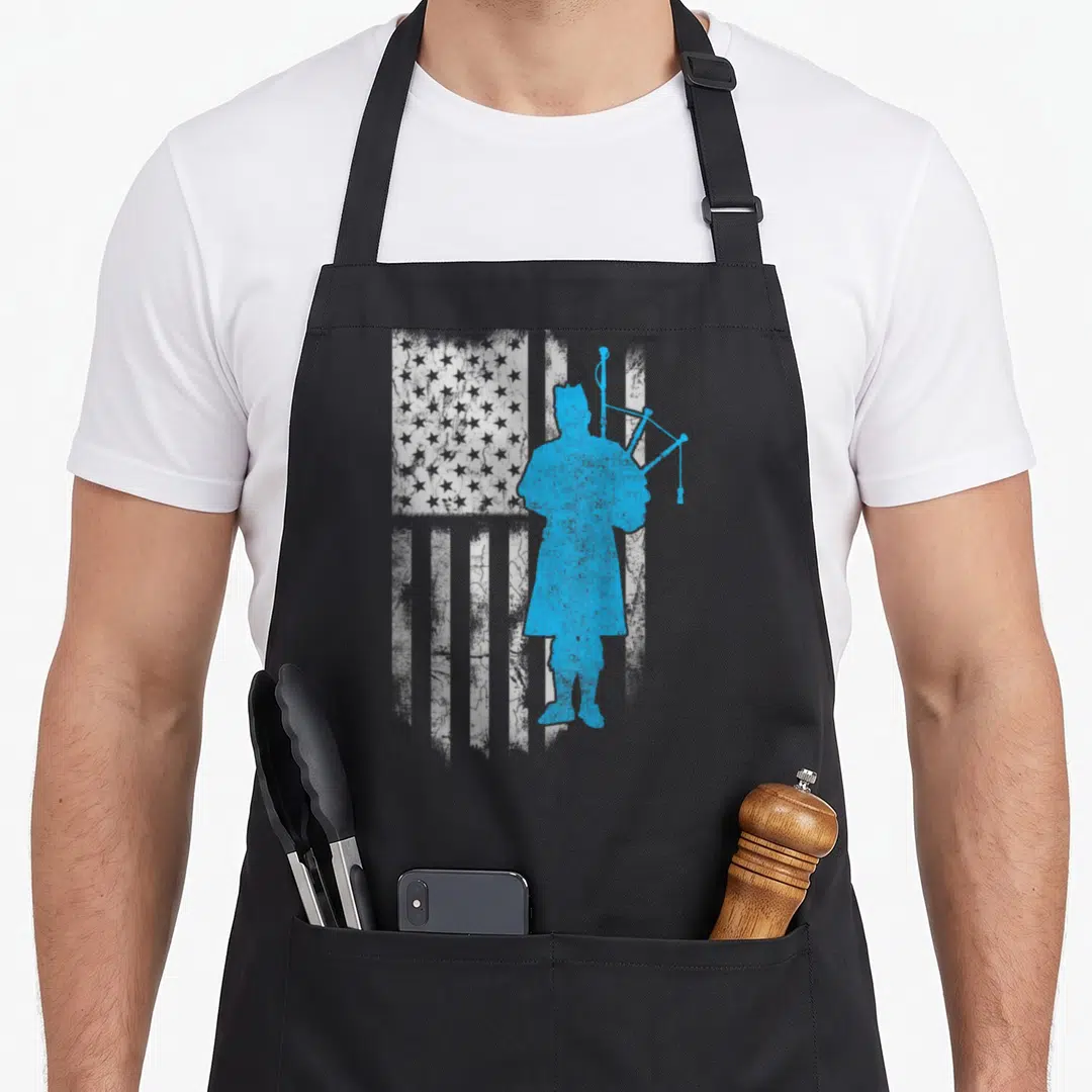 Blow kilt apron - Blue minuteman silhouette with bagpipes over distressed white USA flag — shown on a black cotton canvas apron against a white background