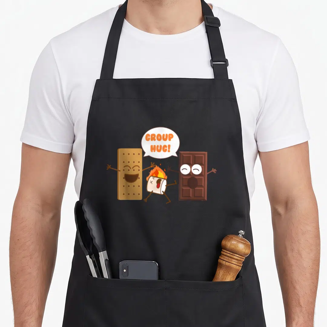Chocolate camping apron - Burning marshmallow between cracker and chocolate with Group Hug text — shown on a black cotton canvas apron against a white background
