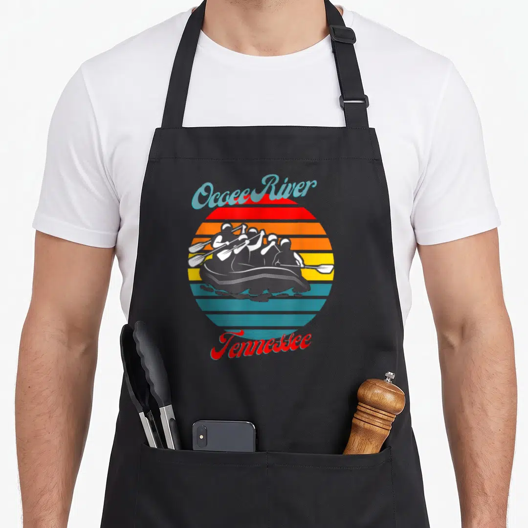 Ocoee canoeing apron - Retro sun graphic with rafters and Ocoee River Tennessee text in red orange yellow blue grey — shown on a black cotton canvas apron against a white background