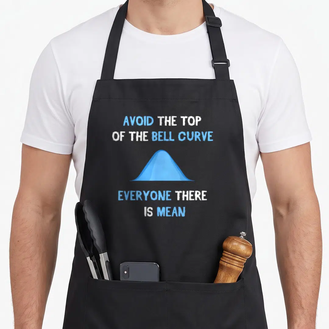 Scientist engineer apron - Blue bell curve with text AVOID THE TOP OF THE BELL CURVE EVERYONE THERE IS MEAN — shown on a black cotton canvas apron against a white background