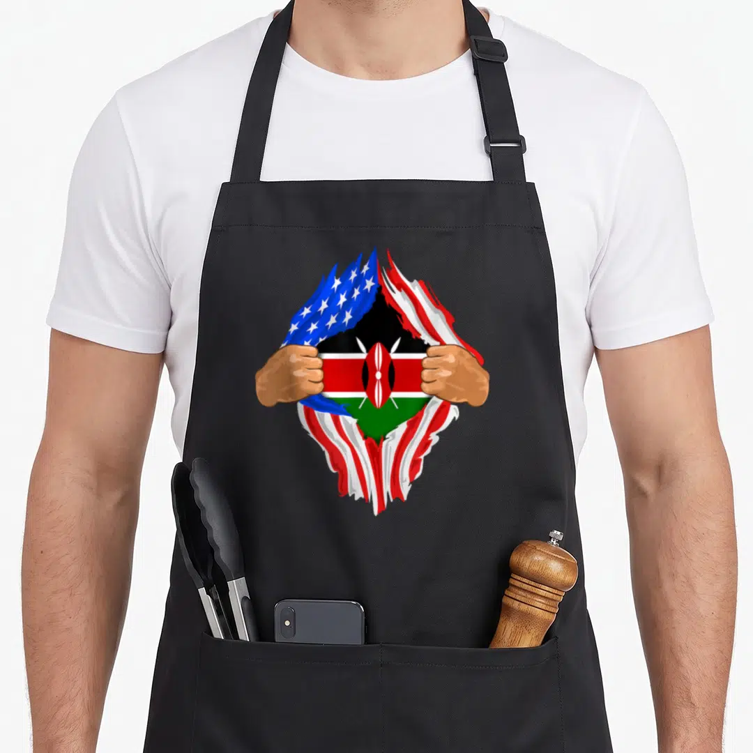 Kenyan blood apron - Two hands tearing red white and blue USA flag to reveal black red green Kenyan flag — shown on a black cotton canvas apron against a white background