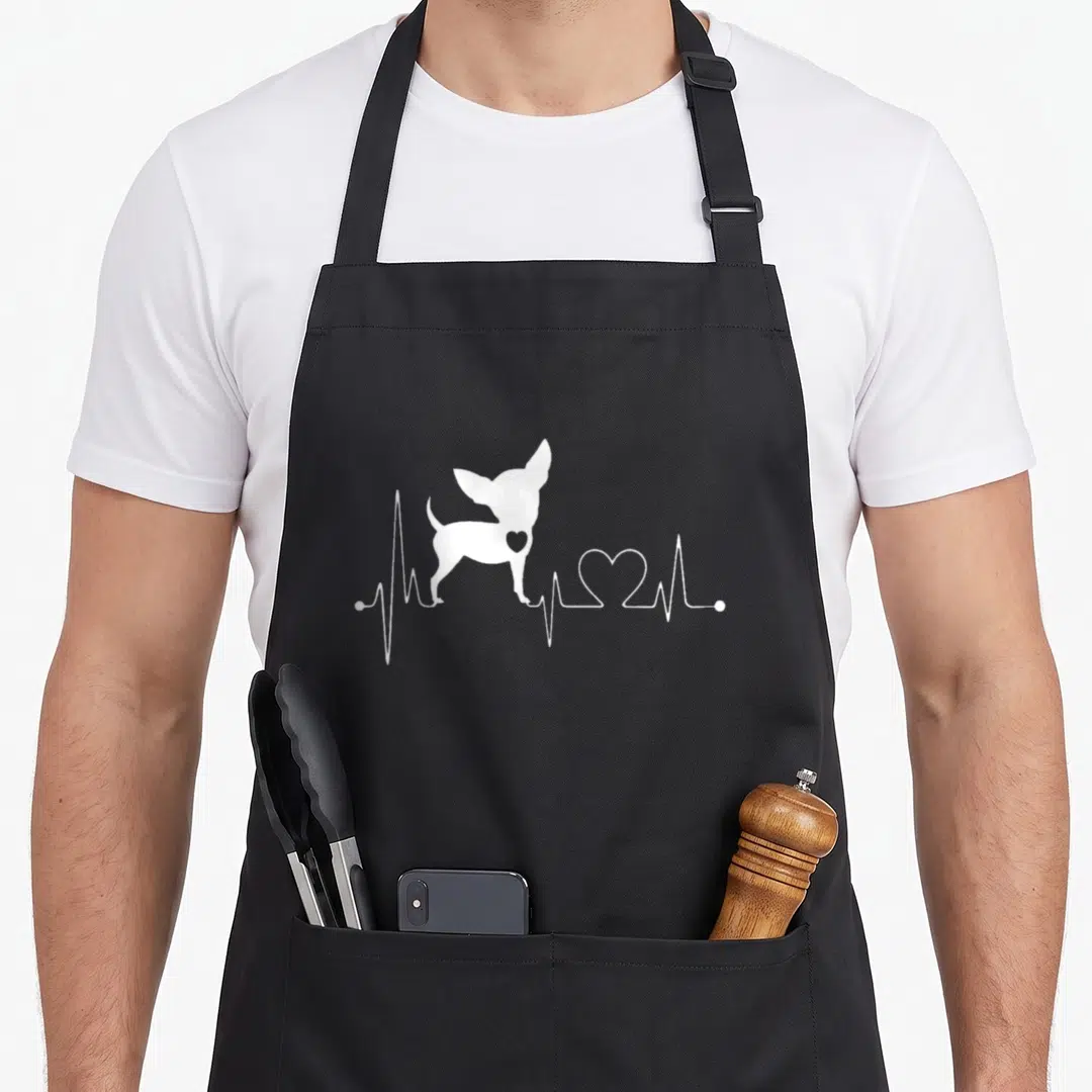 Heartbeat dog apron - White chihuahua silhouette standing on a heartbeat line with a heart shape — shown on a black cotton canvas apron against a white background