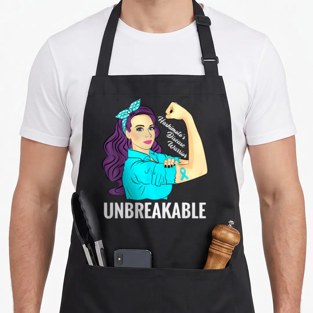 Hashimoto disease thyroid apron - Cartoon woman flexing arm with purple hair, blue shirt, and white text reading — shown on a black cotton canvas apron against a white background