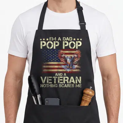 Flying father day apron - Eagle over distressed US flag with I'm a Dad Pop Pop Veteran text — shown on a black cotton canvas apron against a white background