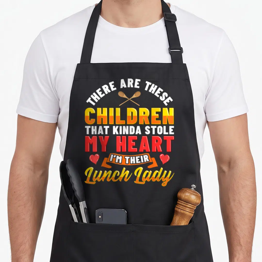 Teacher cafeteria aprons - Stacked text with crossed spoons, hearts, and orange ribbon reading There Are These Children — shown on a black cotton canvas apron against a white background