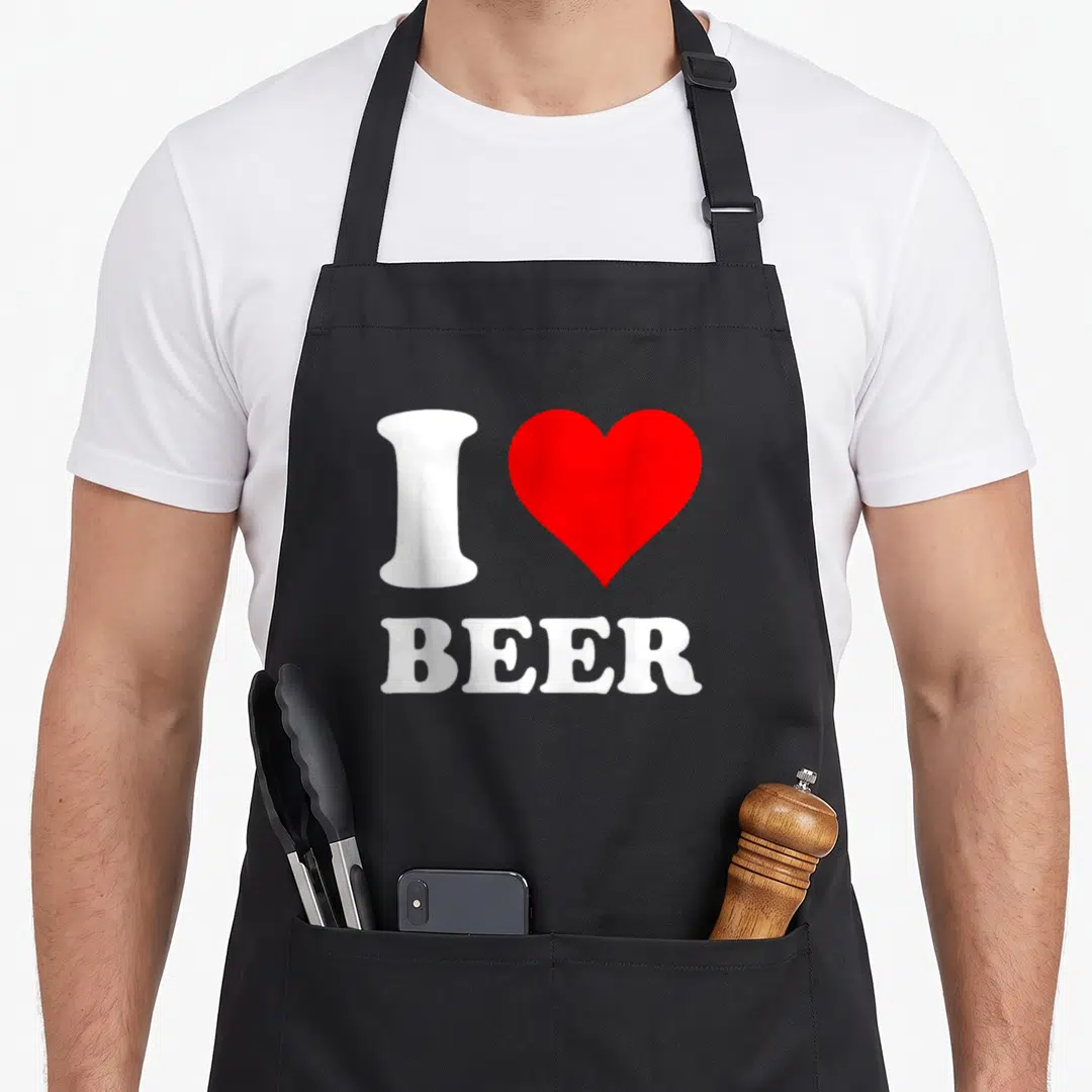 Vintage beer apron - White letter I shaped like a bottle next to red heart above word BEER — shown on a black cotton canvas apron against a white background