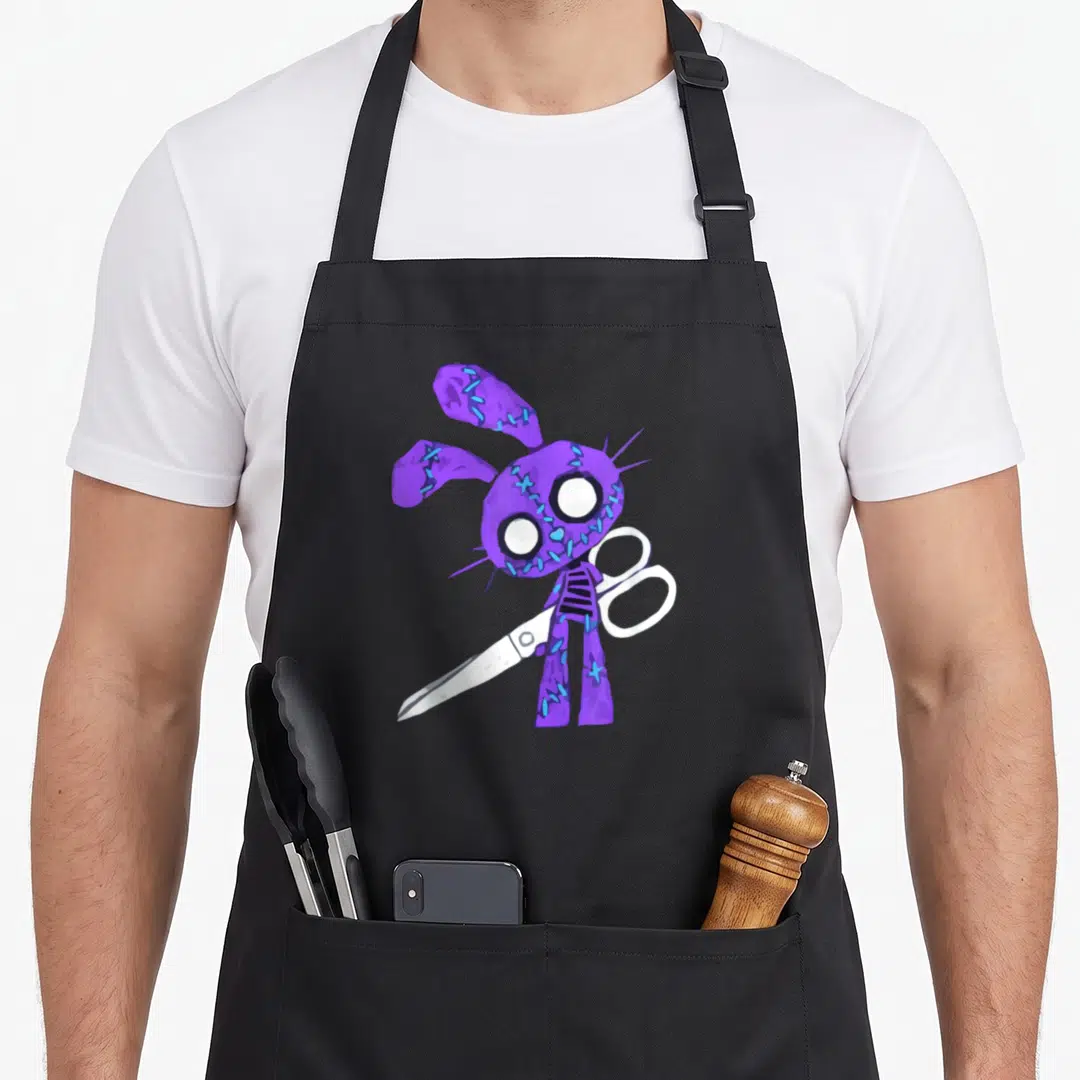 Scissor bunny apron - Purple stitched cartoon rabbit holding white scissors on black background — shown on a black cotton canvas apron against a white background