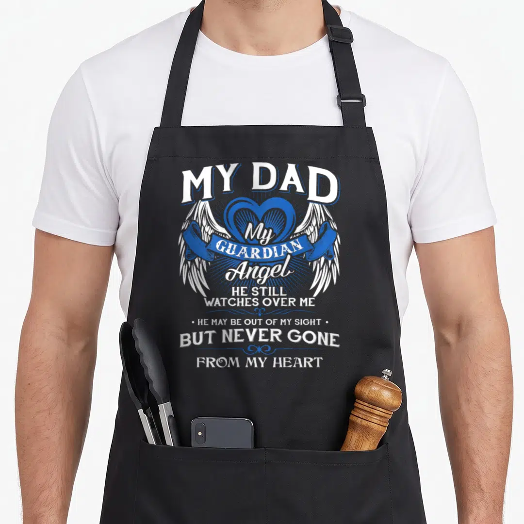 Guardian watch angels and aprons - White angel wings flanking a blue heart with a ribbon banner and memorial text about — shown on a black cotton canvas apron against a white background