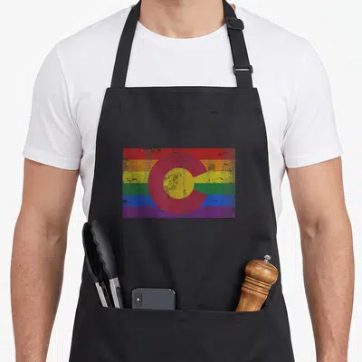 Colorado lgbt gay pride apron - Distressed rainbow flag with red C and yellow circle overlay — shown on a black cotton canvas apron against a white background