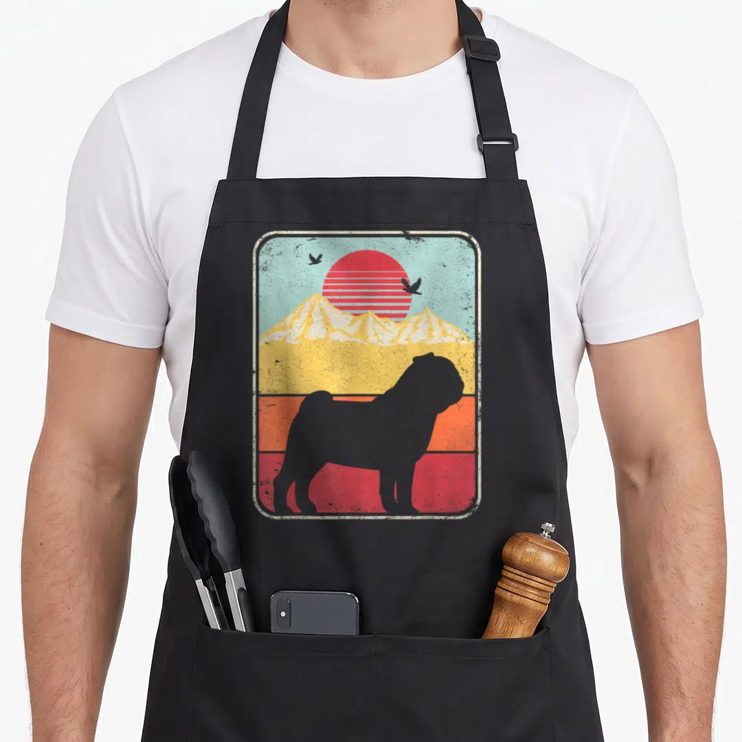 Funny pug apron - Grey pug silhouette against retro sunset with red yellow blue stripes and mountains in rectangular — shown on a black cotton canvas apron against a white background