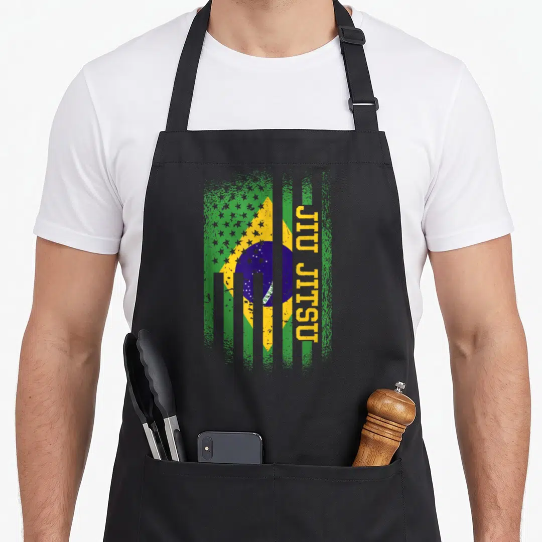 Jitsu american flag apron - Distressed Brazilian flag with vertical yellow JIU JITSU text in green and blue — shown on a black cotton canvas apron against a white background