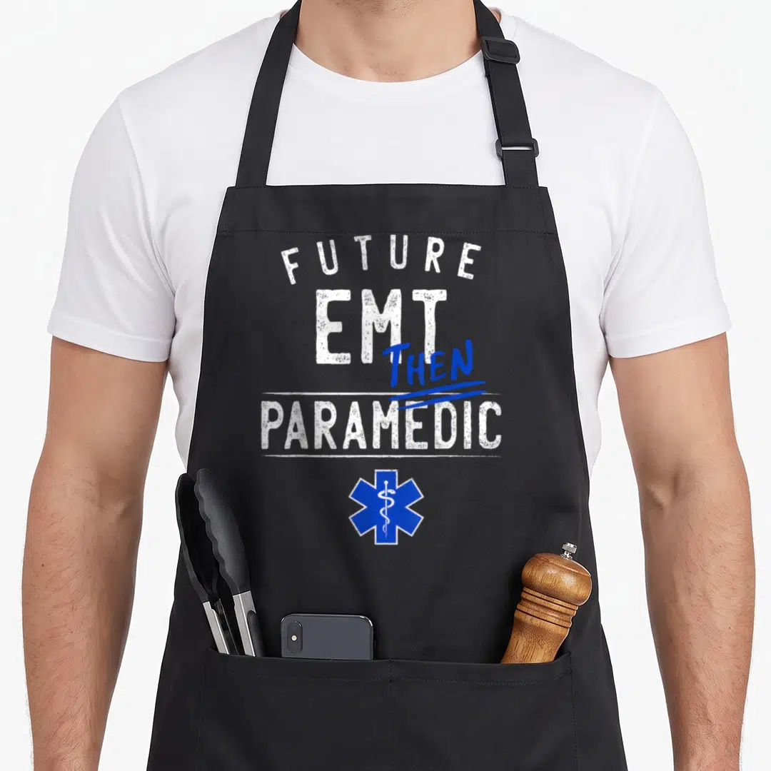 Emt future class apron - Future EMT Then Paramedic text and blue Star of Life symbol — shown on a black cotton canvas apron against a white background