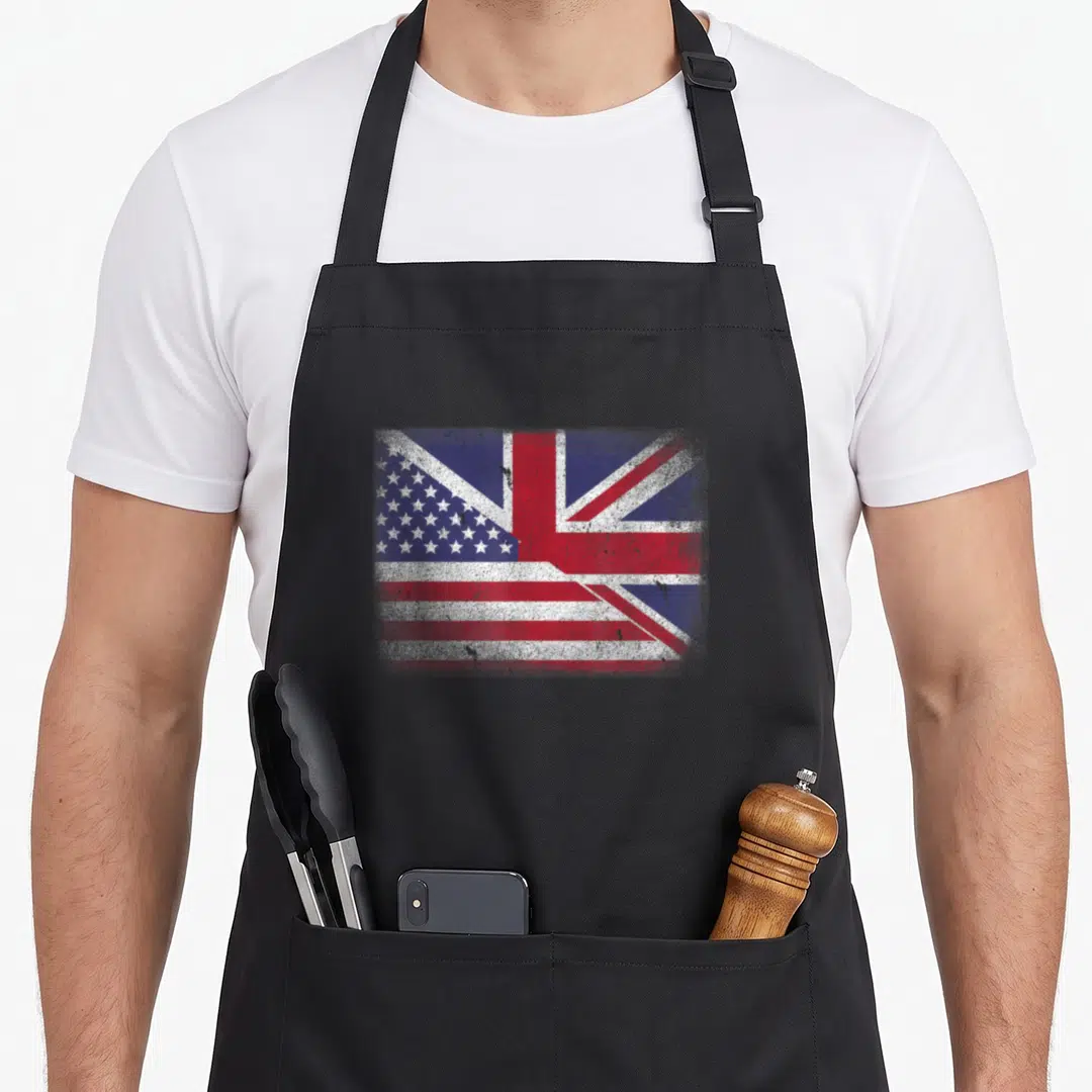 Britain american flag apron - Rectangular distressed hybrid flag combining US stars and UK Union Jack in red white blue — shown on a black cotton canvas apron against a white background