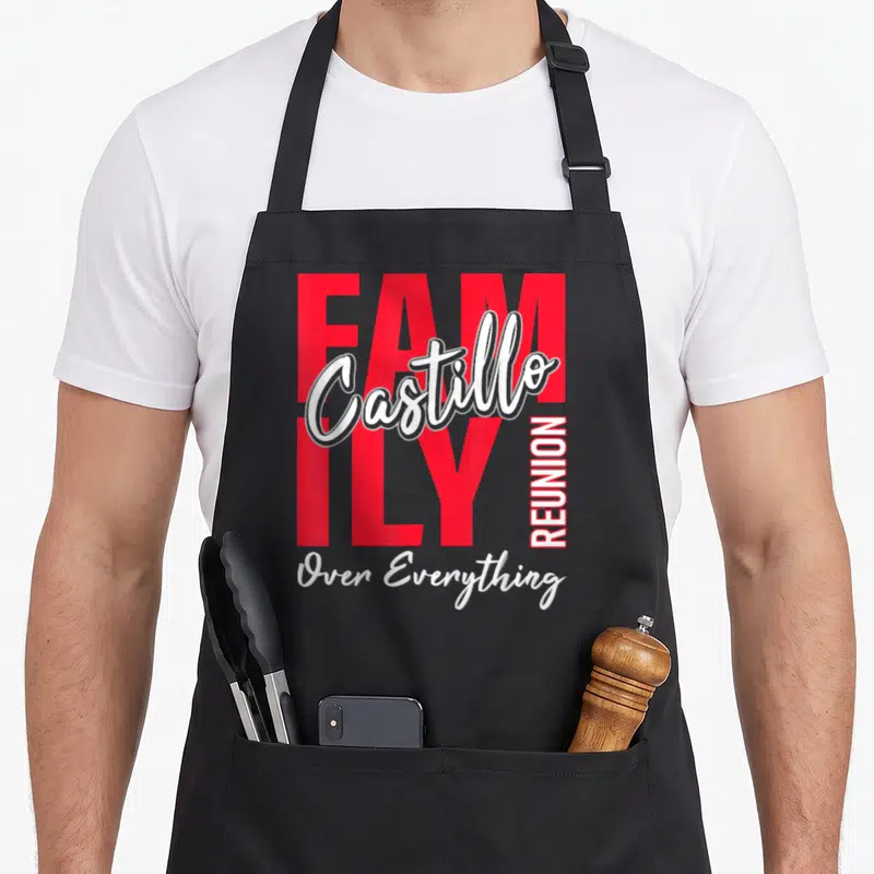Castillo gathering apron - Red and white typography reading FAMILY Castillo REUNION Over Everything on a black — shown on a black cotton canvas apron against a white background