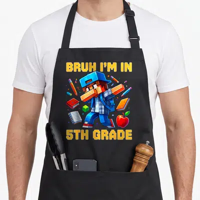 Bruh fifth grade apron - Pixel art boy surrounded by pencils books and apple with stacked yellow text — shown on a black cotton canvas apron against a white background