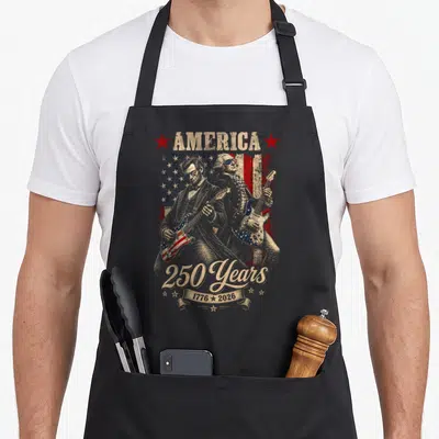 Cute playing guitar apron - Distressed skeleton musicians playing guitars with AMERICA 250 Years 1776 2026 text on flag — shown on a black cotton canvas apron against a white background