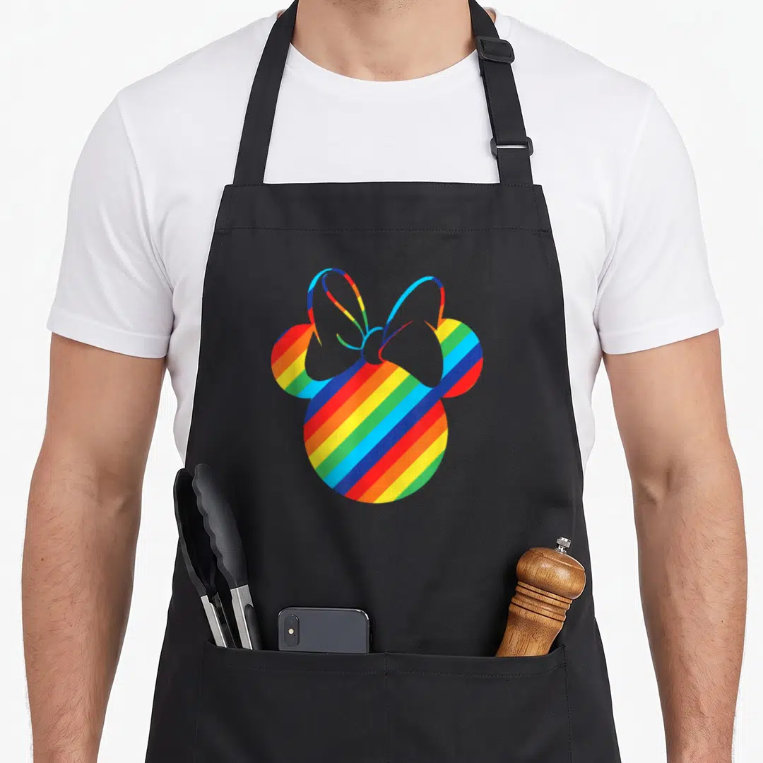 Silhouette rainbow apron - Mouse head silhouette filled with diagonal red orange yellow green blue purple stripes — shown on a black cotton canvas apron against a white background