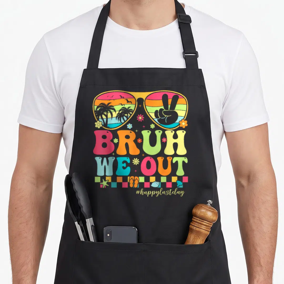 Groovy teacher apron - Retro sunglasses with beach scene, BRUH WE OUT text, and beach items in yellow pink orange blue — shown on a black cotton canvas apron against a white background