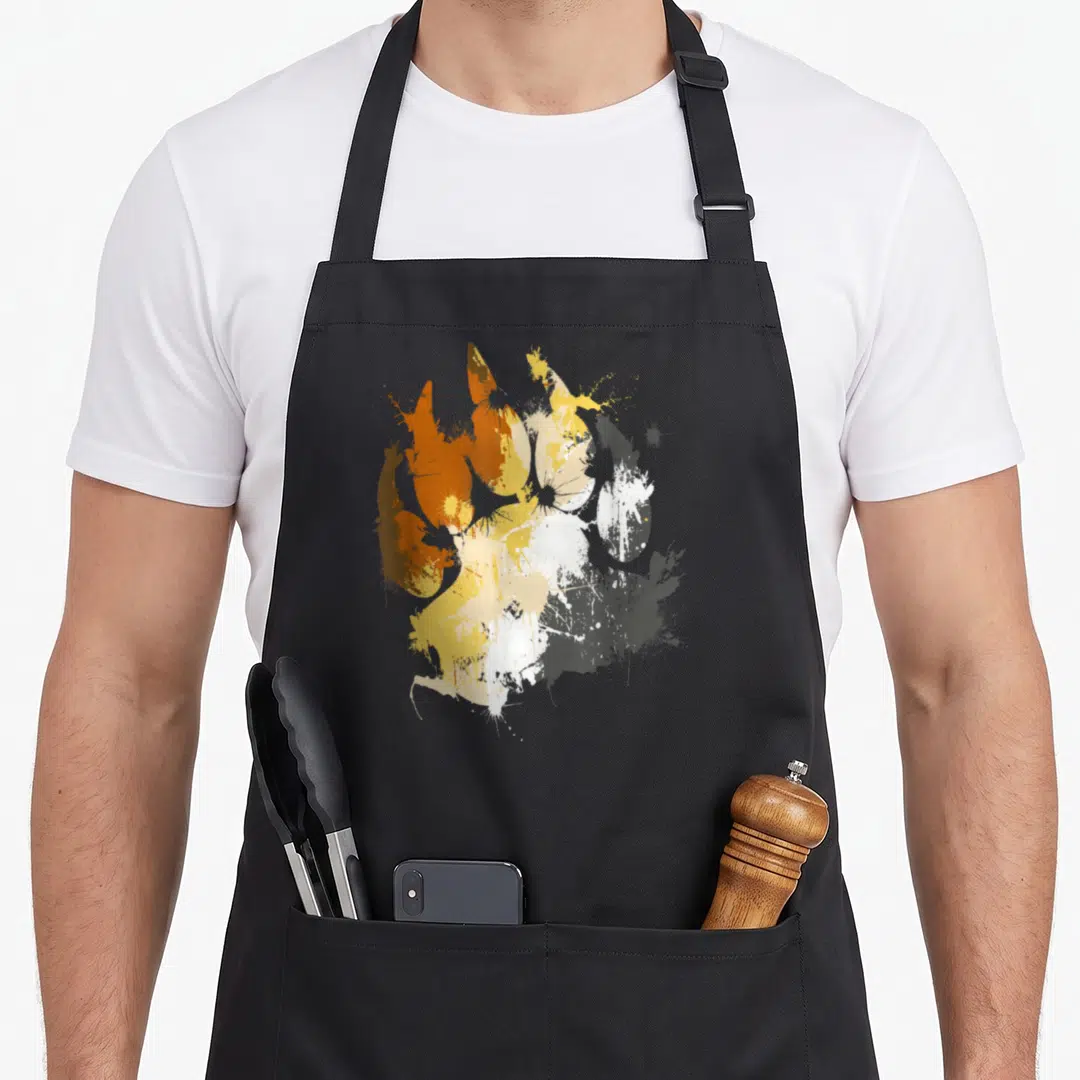 Artdigg gay pride apron - Splatter watercolor bear paw print in orange yellow white and grey — shown on a black cotton canvas apron against a white background