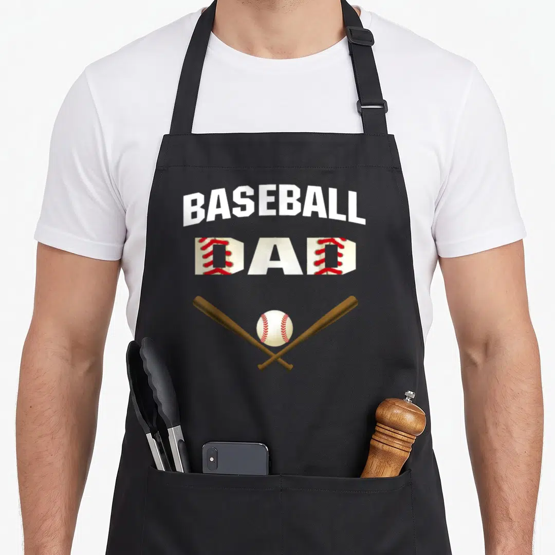 Father baseball apron - BASEBALL DAD text with stitched Ds, two crossed bats, and a baseball — shown on a black cotton canvas apron against a white background