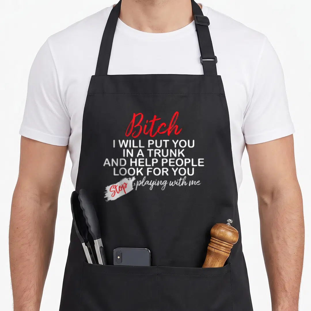 Trunk funny b apron - Red and white stacked typography with white paint stroke highlighting the word Stop on a grey — shown on a black cotton canvas apron against a white background