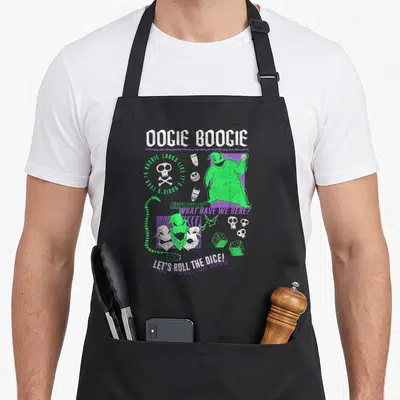 Poster christmas apron - Oogie Boogie figure with dice masks skulls and distressed green purple white lettering — shown on a black cotton canvas apron against a white background