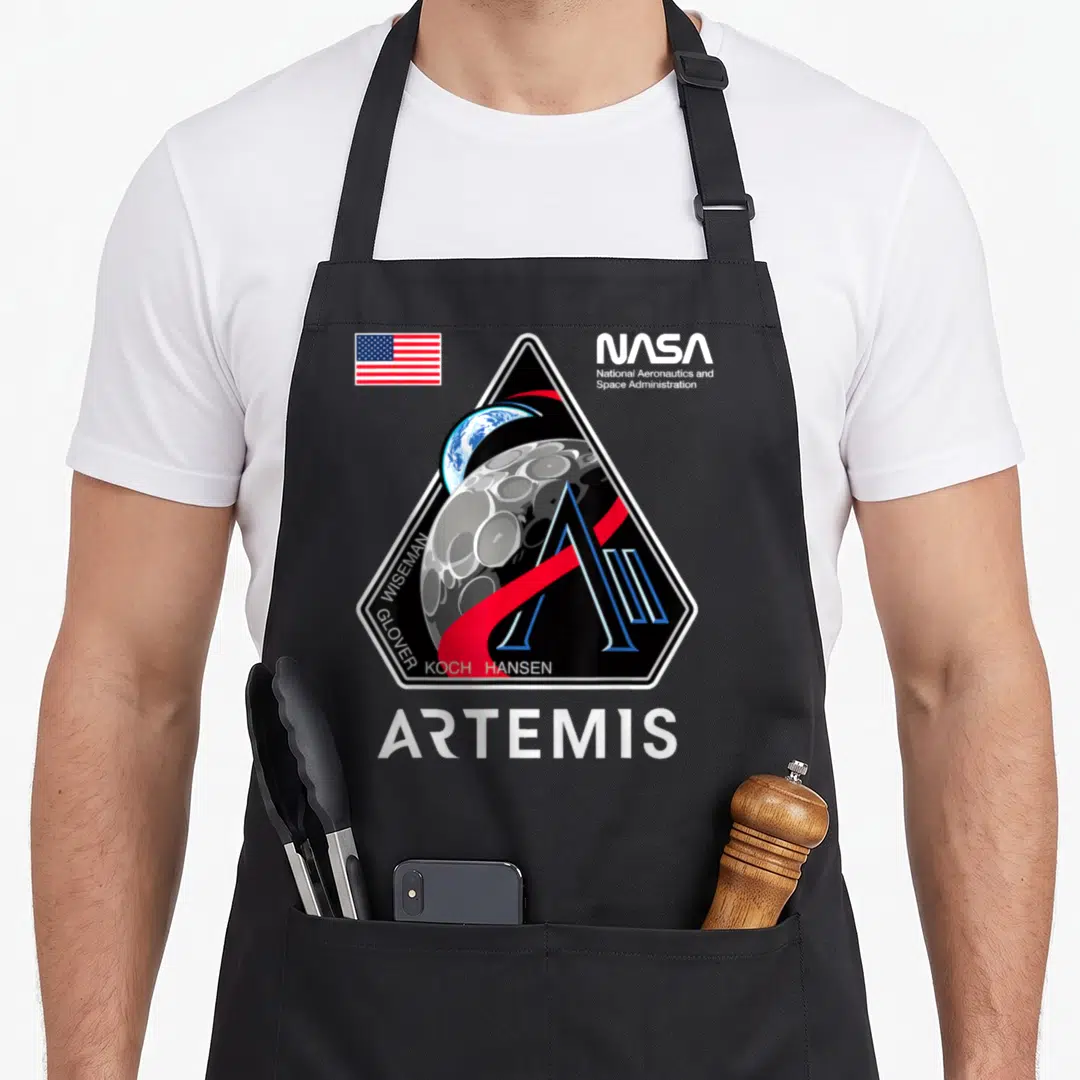 Patch nasa apron - Artemis mission patch with Earth moon NASA logo USA flag crew names ARTEMIS text — shown on a black cotton canvas apron against a white background