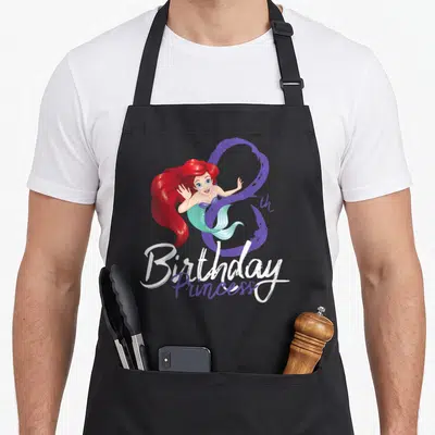 Ariel 8th princess apron - Cartoon mermaid overlapping purple 8 with Birthday Princess text in white and purple script — shown on a black cotton canvas apron against a white background