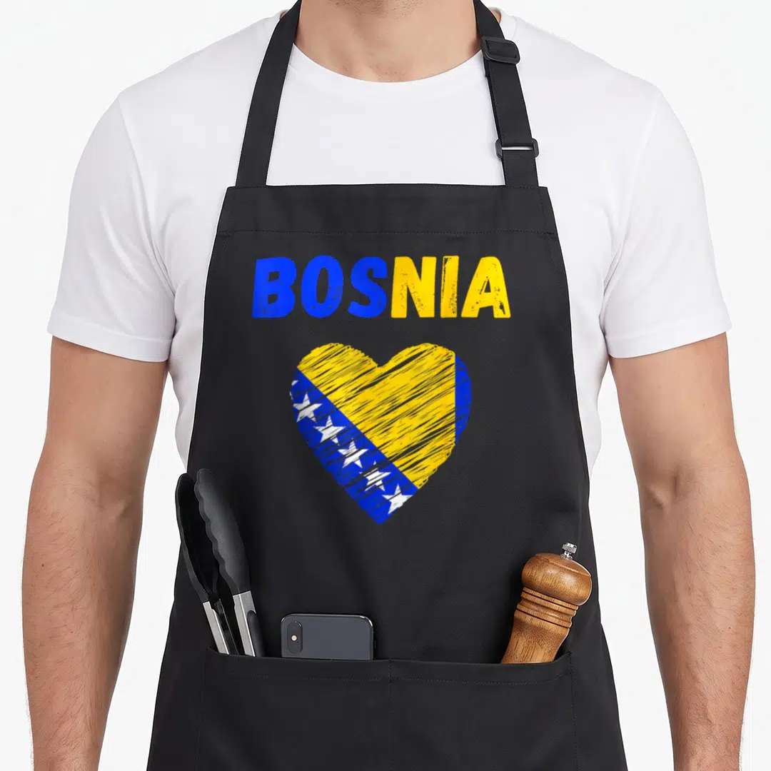 Bosnia holiday apron - Distressed heart filled with blue yellow and white flag pattern below bold text — shown on a black cotton canvas apron against a white background