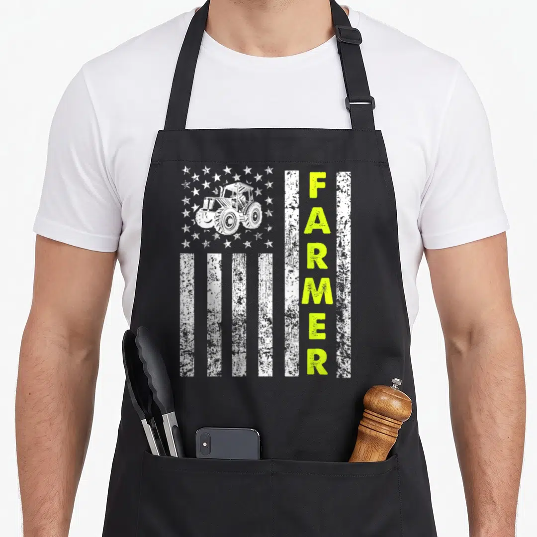 Patriotic farmer apron - Tractor inside white stars with vertical lime green FARMER text over distressed white stripes — shown on a black cotton canvas apron against a white background