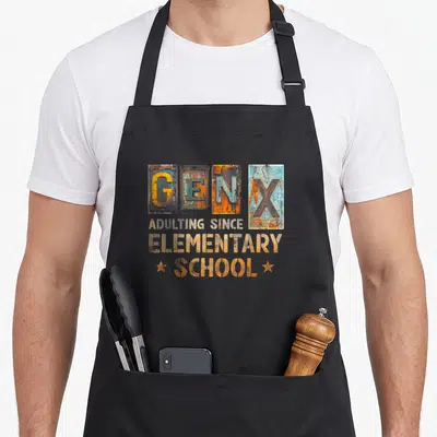 Adulting x apron - Stacked GEN X text in rusty orange and blue rectangles with stars — shown on a black cotton canvas apron against a white background