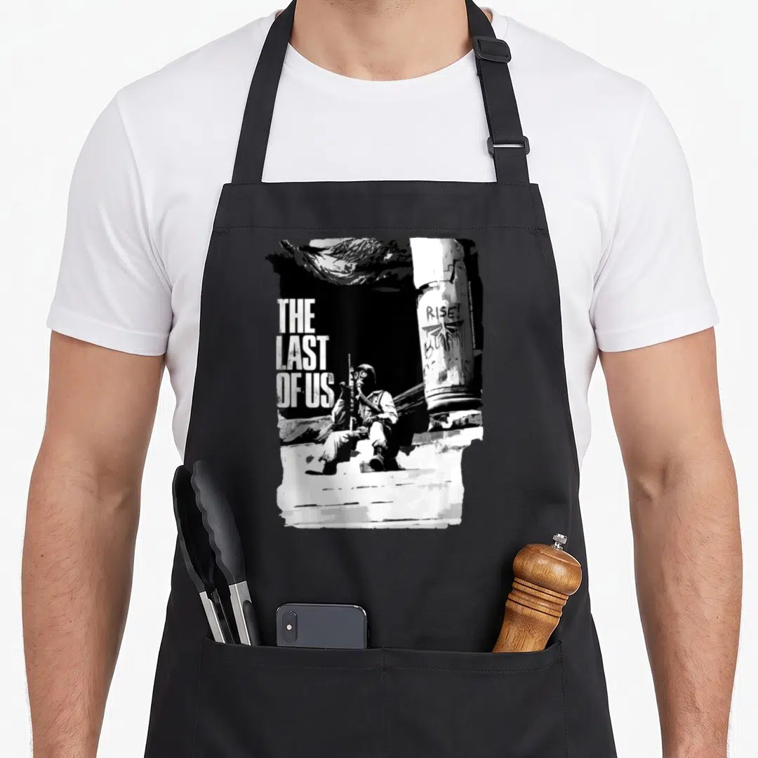 Funny hunter apron - Distressed text reading THE LAST OF US RISE next to a seated gas-masked figure beside a graffiti — shown on a black cotton canvas apron against a white background