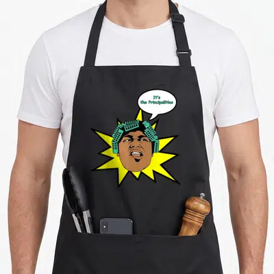 Worm black friday apron - Cartoon man head with teal rollers and text It's the Principalities inside a yellow starburst — shown on a black cotton canvas apron against a white background