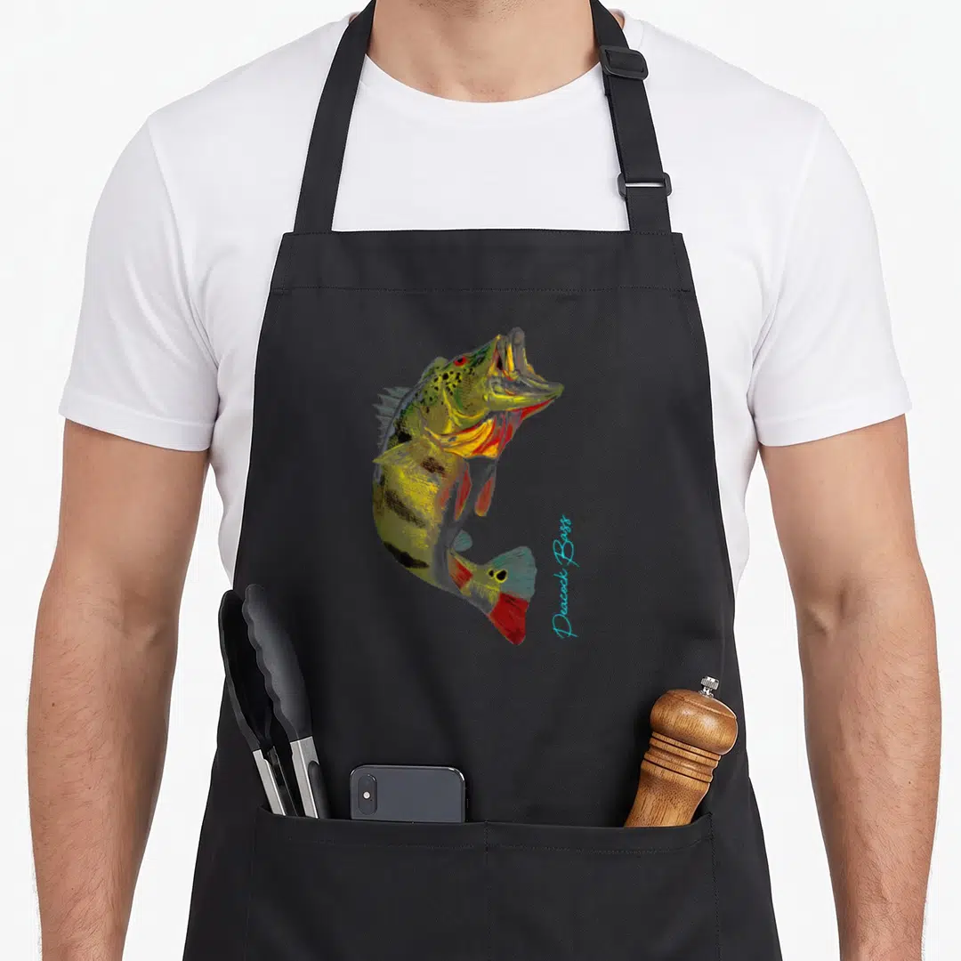 Cute bass fishing aprons - Realistic peacock bass illustration with green yellow red blue colors and vertical light — shown on a black cotton canvas apron against a white background