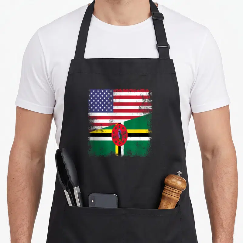 Flag dominican pride apron - Distressed split US and Dominica flag design with parrot emblem in red white blue green — shown on a black cotton canvas apron against a white background