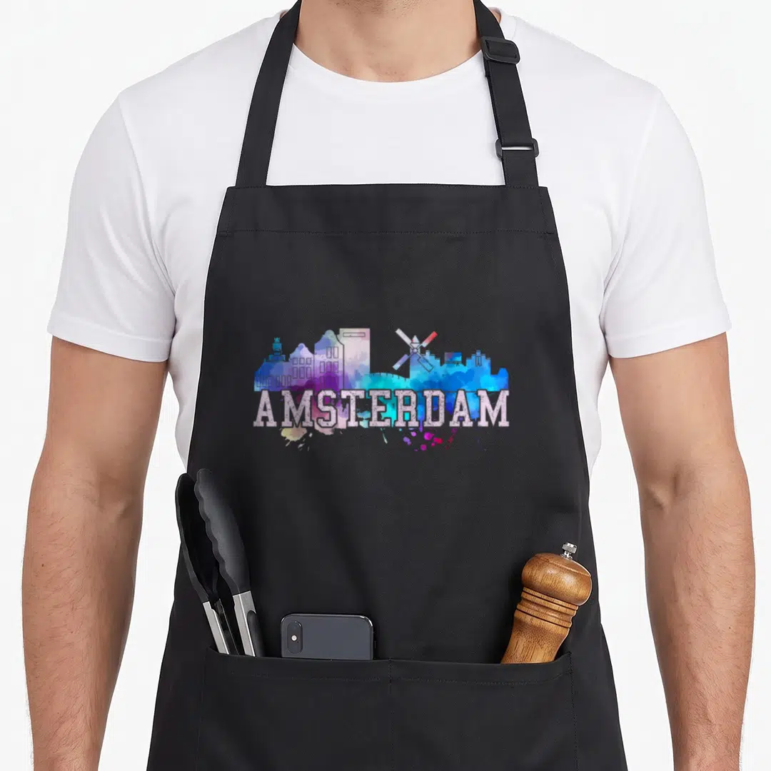 Amsterdam dutch boy apron - Multicolored watercolor Amsterdam skyline with windmill and white text — shown on a black cotton canvas apron against a white background